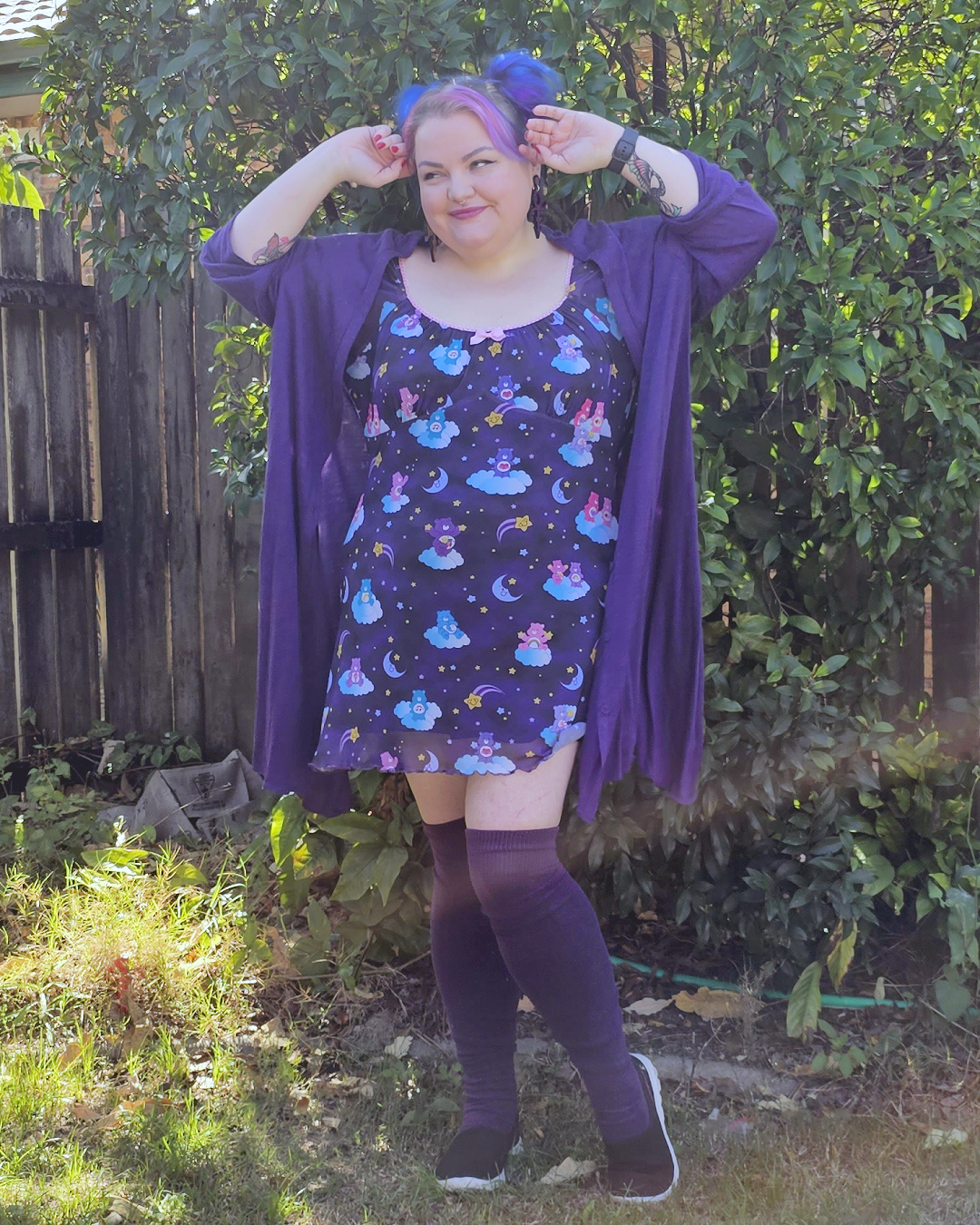 Plus sized girl with pink and purple hear wearing a purple care bears dress