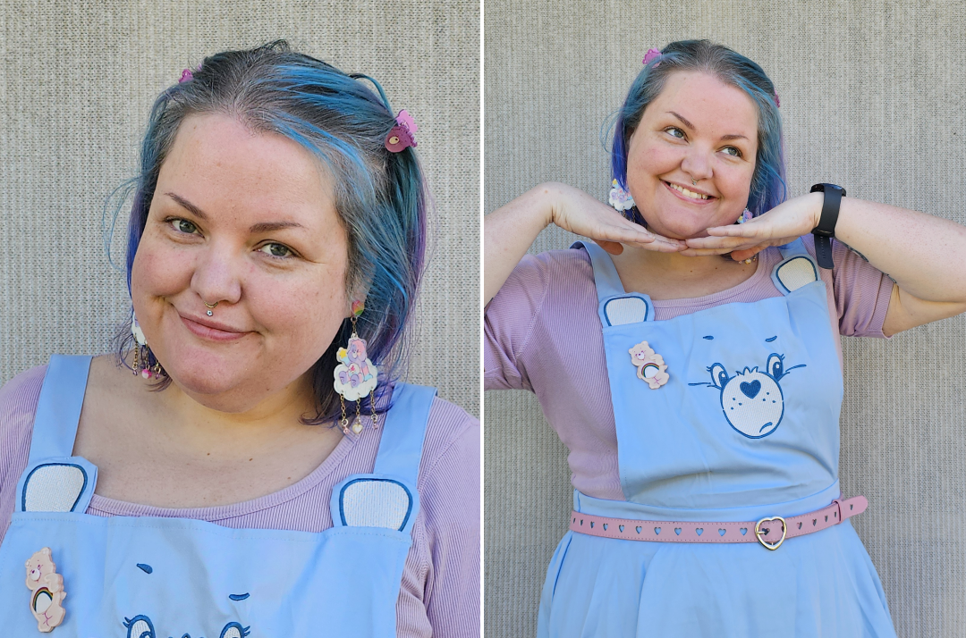 Two photos of a chubby girl with shoulder length blue hair. One is a close up of her face to show off her care bear earrings and hair clips. The second is torso up. She is wearing a blue grumpy bear pinafore with a cheer bear brooch.